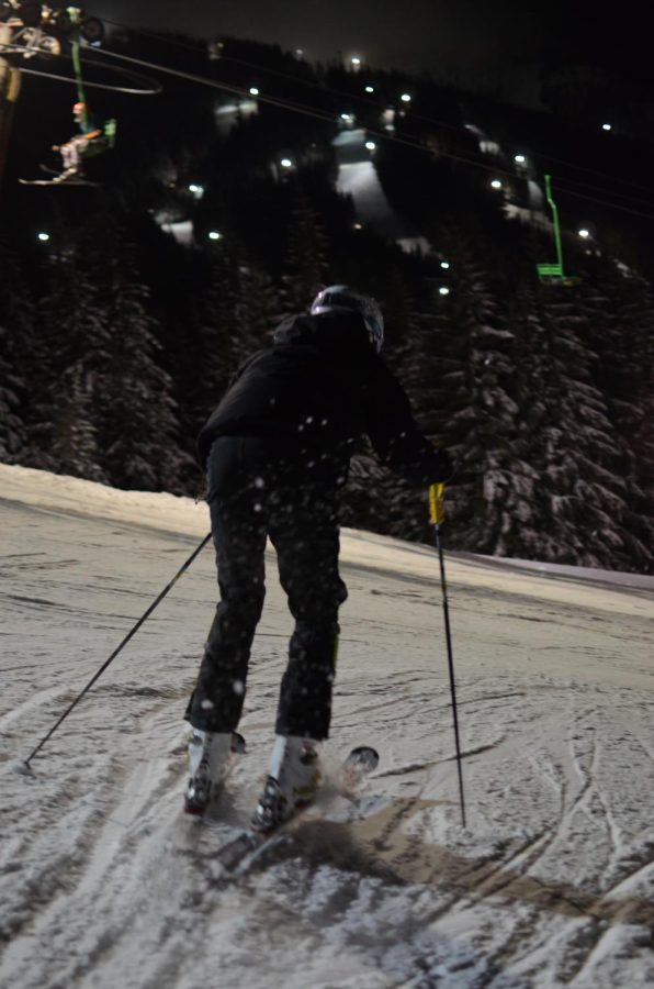 A racer prepares for a practice run during a night ski session. 