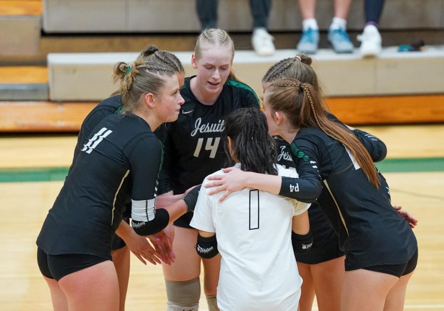 Varsity Womens volleyball team huddle during a match.