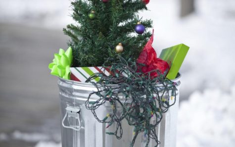 A trash can filled with lights, a tree, and other holiday trash.