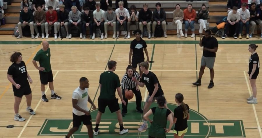 Students and staff look to tip off the annual basketball game. The faculty won.