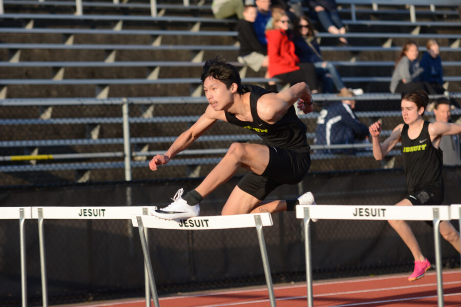 Joseph Hsin competes in the hurdles at a spring track meet.
