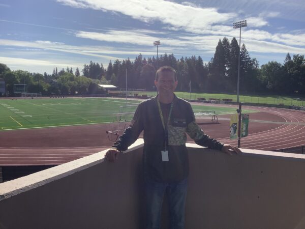 Mr. Kessler in front of Cronin Field where he coaches both Football and Track.