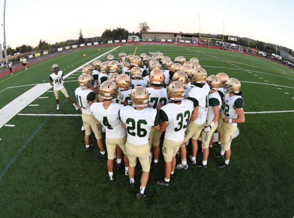 The Jesuit Crusader varsity football team gathers together before a game last season against Sherwood. 