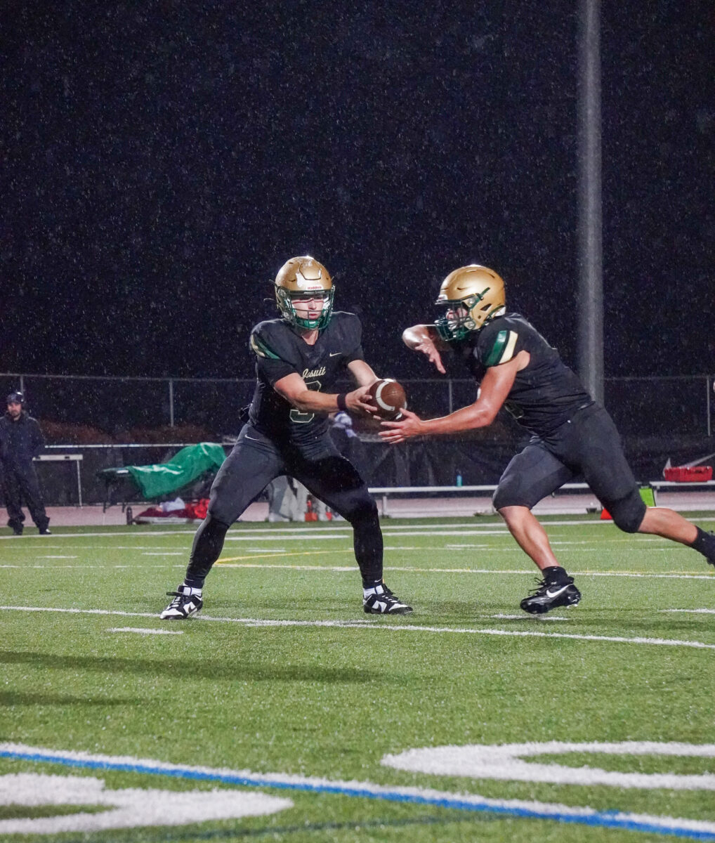 Lonnie Burt takes the handoff from Treynor Cleeland during Jesuits victory over Sunset at Cronin Field on October 13th.