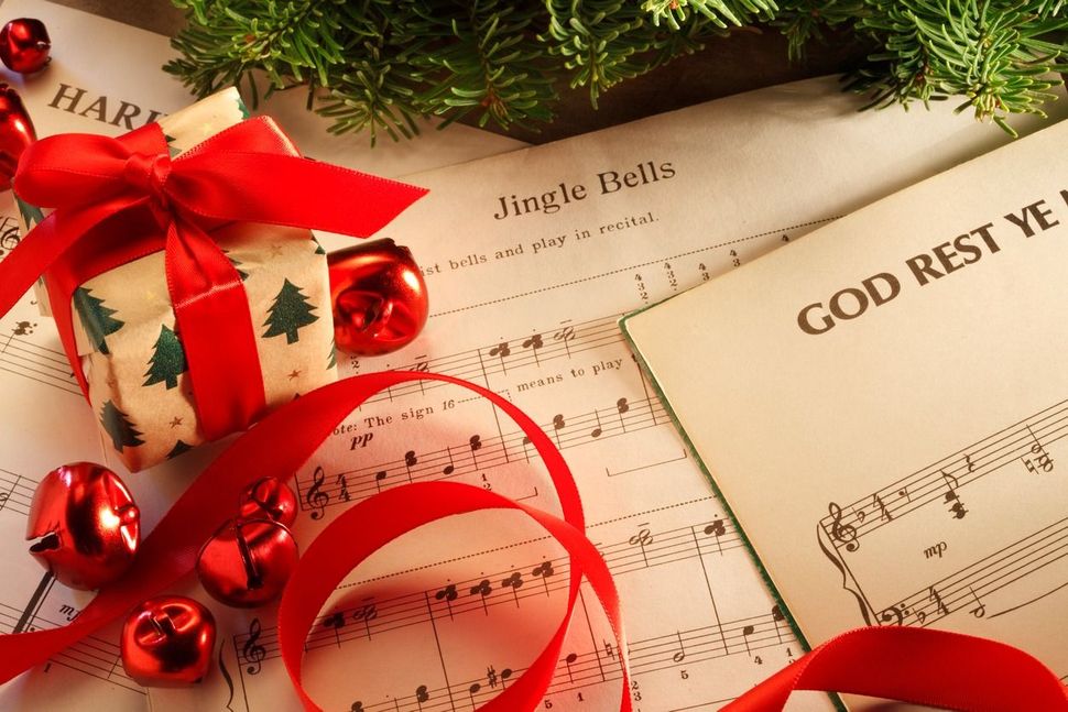 Popular Christmas music with Christmas presents on top of music sheets.