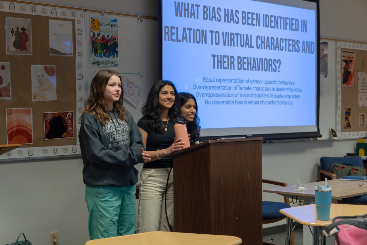 Lucy Robb, Shonali Chakravarty, and Shruthi Prudvi having students participate in an activity.
