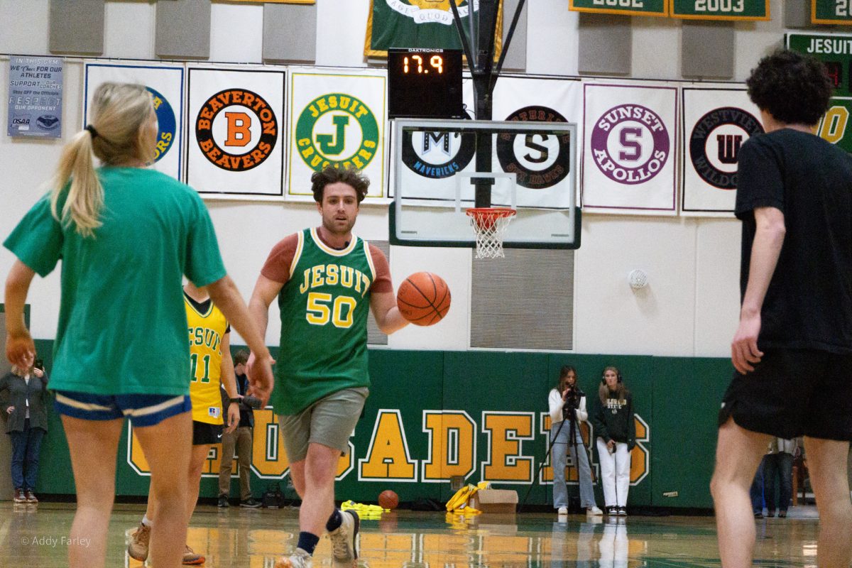Mr. Shoultz brings the ball up the court against the students in the annual faculty vs students basketball game.