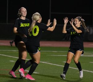 Women's soccer celebrates a goal. 