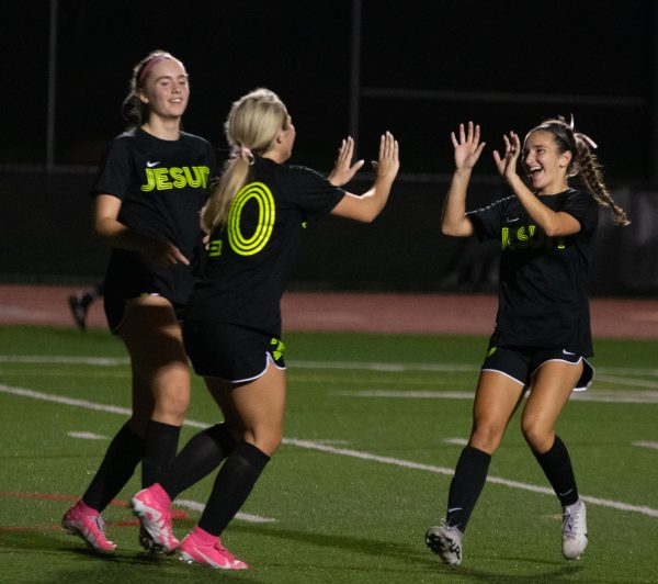 Women's soccer celebrates a goal.