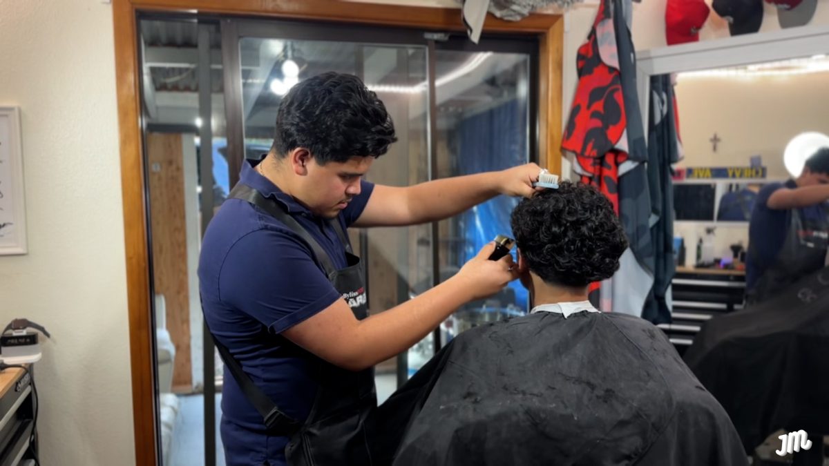 Andrew Reyes cutting a client's hair in his studio at home