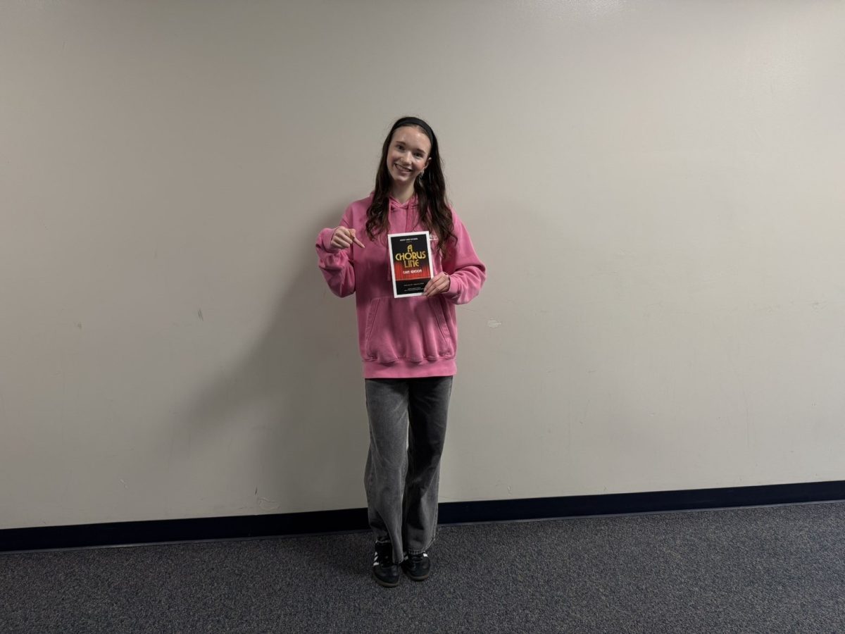Hannah Macielinski shows a poster from A Chorus Line.